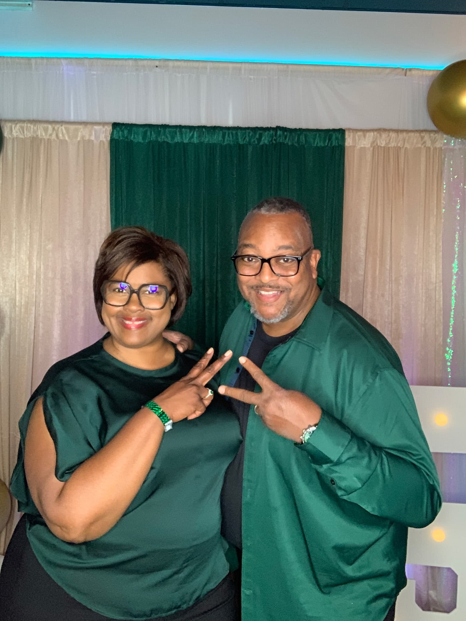 Guests posing in front of a draped backdrop at the digital photo booth station